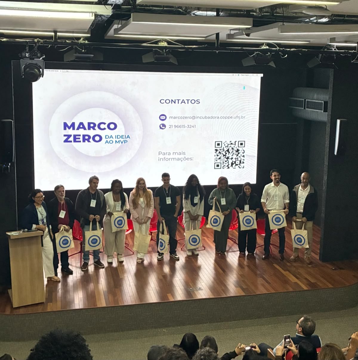 Empreendedores selecionados pelo Marco Zero no palco, diante do telão do programa